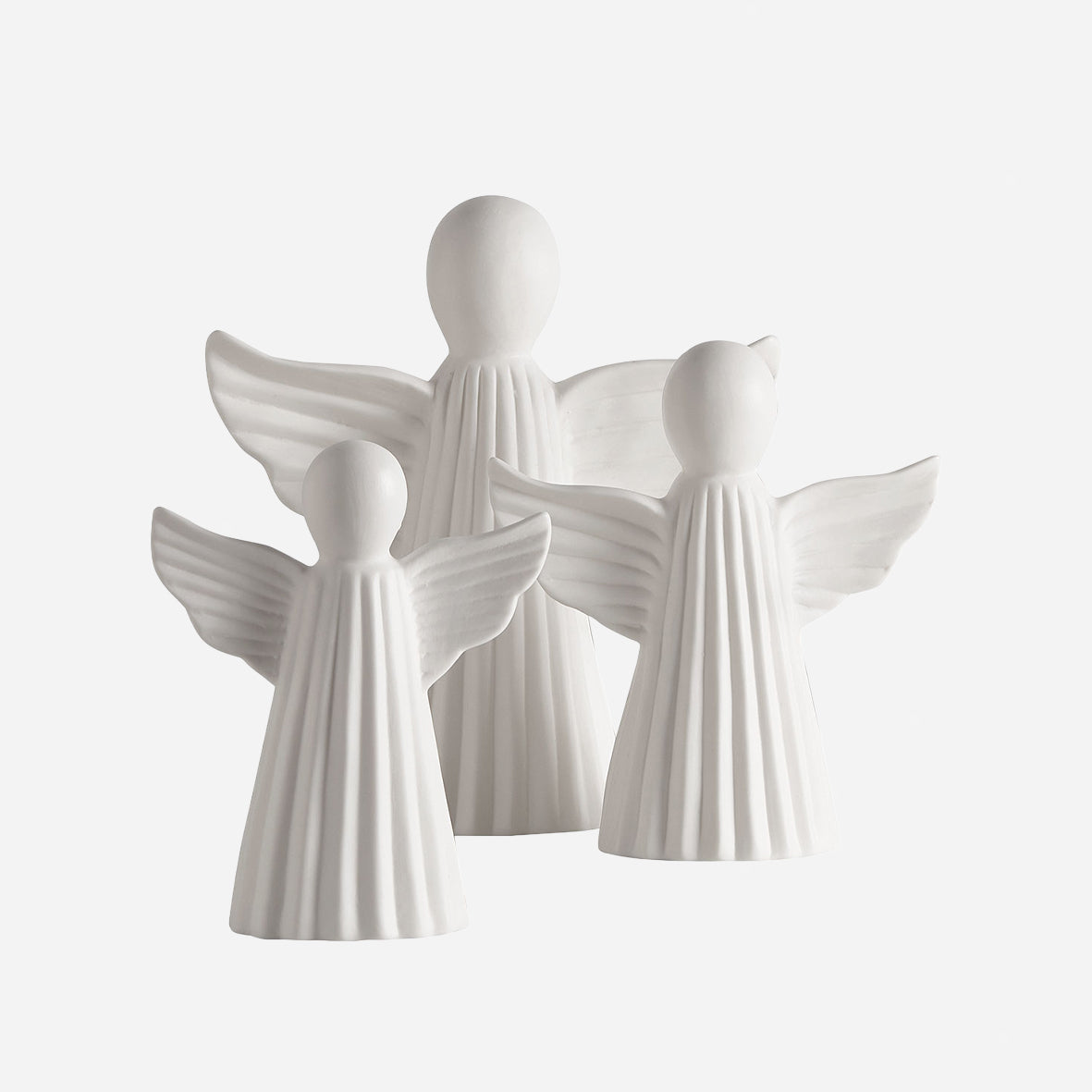 Les 3 anges décoratifs des 3 tailles différentes sur fond gris clair.